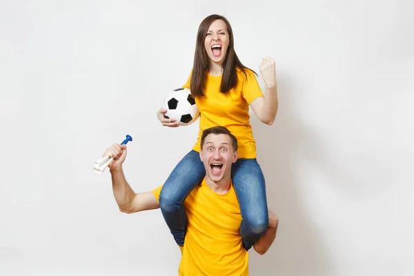 Jeune couple inspiré, femme assise sur les épaules de l'homme, fans avec ballon de football pipe acclamer équipe de football préférée mains gesticulées expressives isolées sur fond blanc. Loisirs en famille, concept lifestyle . — Photo