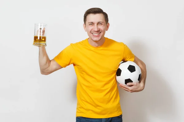 Inspirado joven divertido alegre hombre europeo, ventilador o jugador en uniforme amarillo sostener jarra de cerveza, pelota de fútbol animar equipo de fútbol favorito aislado sobre fondo blanco. Deporte, juego, estilo de vida concepto . — Foto de Stock