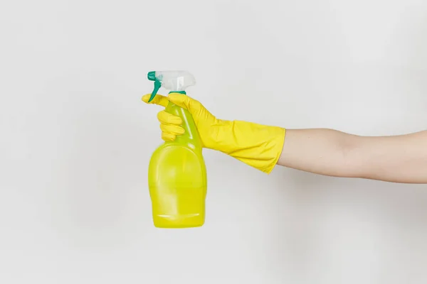 女性手的特写在黄色手套点击黄色喷雾瓶与干净的液体与地方为文本隔绝在白色背景。清洁用品的概念。复制广告空间 — 图库照片
