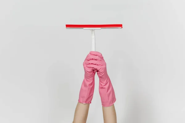 El primer plano de las manos femeninas en guantes rosas horizontales sostiene la escobilla blanca para la limpieza de superficies con elementos rojos aislados sobre fondo blanco. Concepto de artículos de limpieza. Copiar espacio para publicidad — Foto de Stock