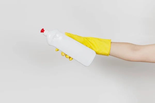 在黄色手套关闭女性手持有白瓶与清洁的液体清洗的地方, 文本隔离在白色背景。清洁用品的概念。为 ad 复制空间 — 图库照片