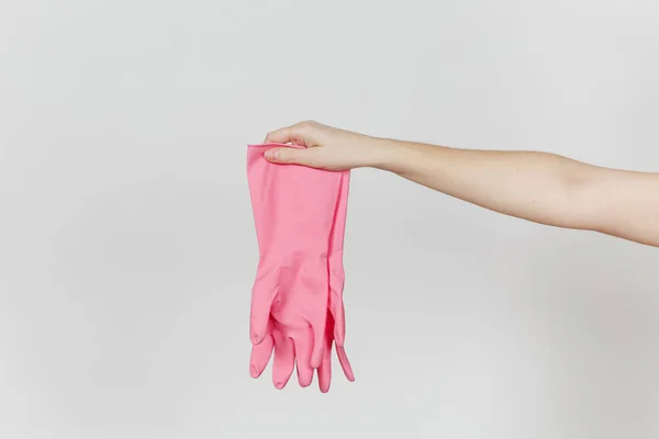 Nahaufnahme der weiblichen Hand hält ein Paar rosa Handschuhe aus Gummi und Latex zum Reinigen und Spülen von Geschirr isoliert auf weißem Hintergrund. Reinigungsmittelkonzept. Kopierfläche für Werbung — Stockfoto