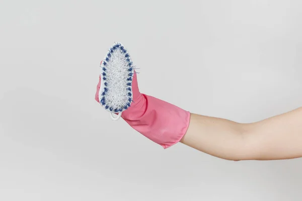 Close up da mão feminina em luvas rosa horizontal mantém escova branca com fibras duras para limpeza com elementos azuis isolados no fundo branco. Conceito de material de limpeza. Espaço de cópia para anúncio — Fotografia de Stock