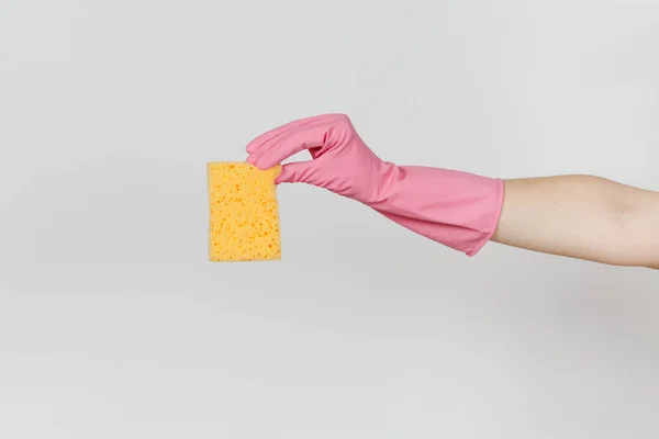 Close up da mão feminina em luvas rosa horizontal mantém esponja amarelo-laranja para a limpeza e lavagem de pratos isolados em fundo branco. Conceito de material de limpeza. Espaço de cópia para propaganda — Fotografia de Stock