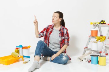 Kadın işaret parmağı bir kenara kopya alanı üzerinde beyaz arka plan üzerinde izole yenileme daire için aygıtlar ile yere otur. Boyama araçları yapıştırma için aksesuarları duvar kağıdı. Onarım kavramı