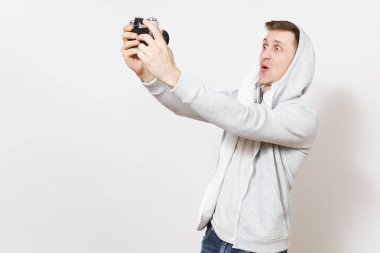 Genç yakışıklı öğrenci tişört ve kukuleta ile kulaklık fotoğraf ile hafif kazak Studio beyaz arka plan üzerinde retro makinesinde kendini heyecanlı. Genel kavram-in fotoğraf, hobi