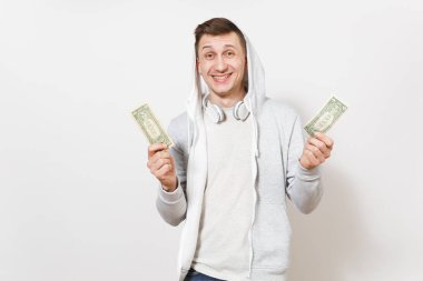 Genç yakışıklı gülümseyen öğrenci tişört, kot ve kulaklık ile hood ile hafif kazak iki dolarlarına tutar ve beyaz arka plan üzerinde Studio sevindiler. Duygular kavramı