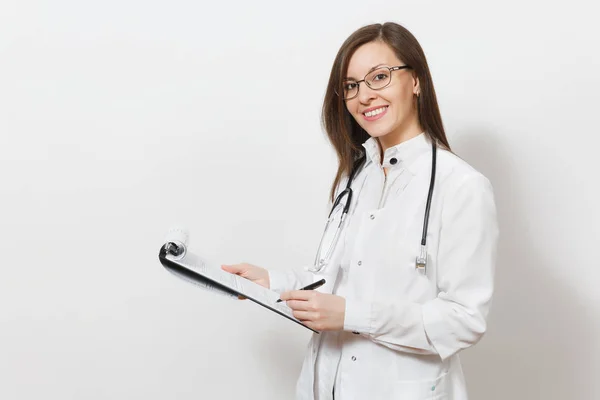 Sorridente giovane donna medico fiducioso con stetoscopio, occhiali isolati su sfondo bianco. Medico donna in abito medico in possesso di tessera sanitaria sulla cartella blocco note. Concetto di medicina del personale sanitario . — Foto Stock