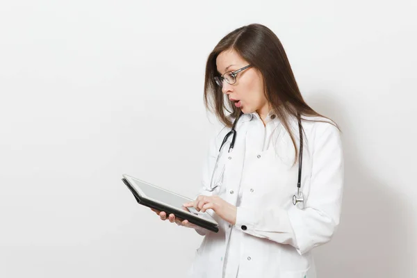 Mujer doctora bastante joven asombrada con estetoscopio, gafas aisladas sobre fondo blanco. Doctora en bata médica con tableta PC. Personal sanitario, concepto de medicina tecnológica . — Foto de Stock