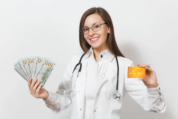 Красива лікарка зі стетоскопом ізольована на білому тлі. Жінка-лікар в медичній сукні тримає грошові купюри, пакет доларів, кредитну картку. Медичний персонал, концепція медицини . — стокове фото