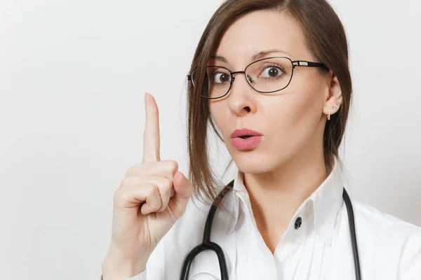 Close up donna medico stupito con stetoscopio, occhiali isolati su sfondo bianco. Medico donna in uniforme medica che punta il dito indice sullo spazio di copia. Personale sanitario, concetto di medicina . — Foto Stock