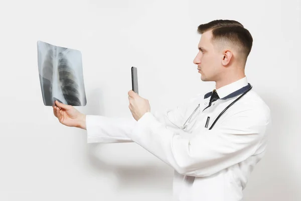 Médico enfocado hombre con rayos X de pulmones, fluorografía, roentgen, tomar fotos en el teléfono móvil aislado sobre fondo blanco. Médico en uniforme médico, estetoscopio. Personal sanitario. Neumonía . — Foto de Stock