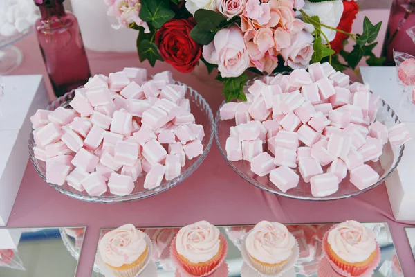 Krásná dekorace svatební obřad v růžové, vínové a bílé tóny na dřevěném molu. Lahodné sladké roztomilý želé máčené v skleněnou desku a muffiny košíčky na sladké bufetového stolu — Stock fotografie