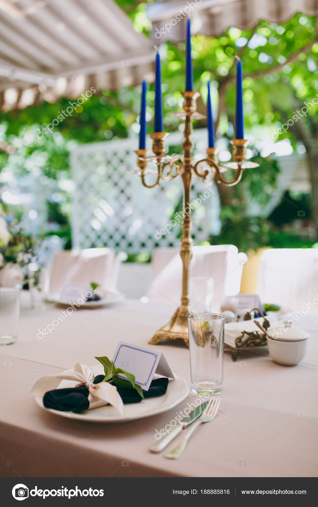 緑豊かな庭園の真ん中に結婚式の祭典の美しく 絶妙な装飾 バンケットのカバーの下にベージュ テーブル クロス 板と青い蝋燭と燭台のテーブルを提供しています ストック写真 C Dmvasilenko 緑豊かな庭園の真ん中に結婚式の祭典の美しく 絶妙な装飾 バンケットのカバーの下にベージュ テーブル クロス 板と青い蝋燭と燭台のテーブルを提供しています ストック写真 C Dmvasilenko