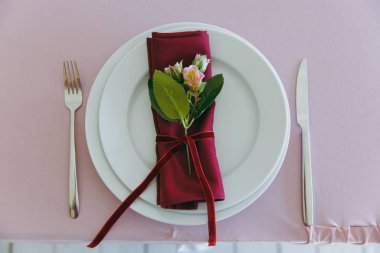 Güzel dekorasyon düğün Ziyafet pembe, Bordo ve beyaz tonlarda tentenin altında. Bir masa örtüsü, tabak, çatal bıçak takımı, peçete, kapalı ayarı tablo çiçek kompozisyonlar dekore edilmiştir.