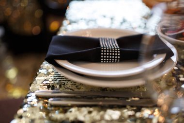 Güzel dekorasyon lüks düğün Ziyafet bir retro tarzı Restoran içinde. Bir yemek masası payetler, tabak, çatal bıçak takımı, kadehlerin ve rhinestones peçeteyle parlak bir masa örtüsü ile hizmet veren