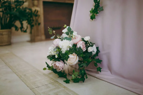 Bela decoração de um banquete de casamento em um restaurante em cores pastel. Elemento decoração perto do vaso de mesa do banquete com um arranjo floral de rosas, peônias e folhas verdes no chão — Fotografia de Stock