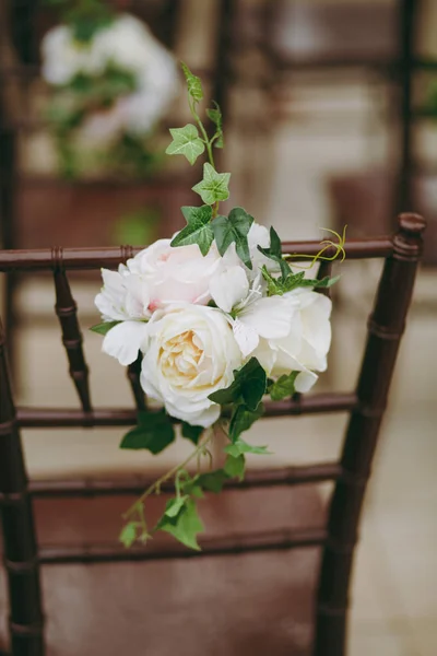 Szép dekoráció, egy esküvő, egy zöld őszi kertben. Vintage barna fa székek vendégek díszített boutonniere-zöld levelek és fehér és rózsaszín pünkösdi rózsa — Stock Fotó