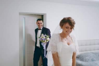 Sabah yeni evliler için hazırlanması düğün töreni. Buket çiçek resmi mavi elbiseli gülümseyen bir damat onu bekledim gelin beyaz elbise ve peçe için oda girer