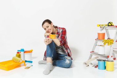 Beyaz arka plan üzerinde izole yenileme daire için aygıtlar ile katta oturan para ile kredi kartı tutan sevimli kadın. Boyama araçları yapıştırma için aksesuarları duvar kağıdı. Onarım ev concept.