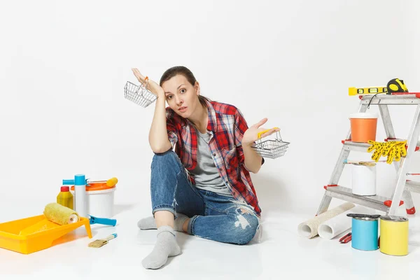 Scioccato sconvolto donna triste tiene cestini metallici alimentari per lo shopping. Strumenti per la ristrutturazione appartamento isolato su sfondo bianco. Carta da parati, accessori, strumenti per la pittura. Riparazione concetto di casa . — Foto Stock