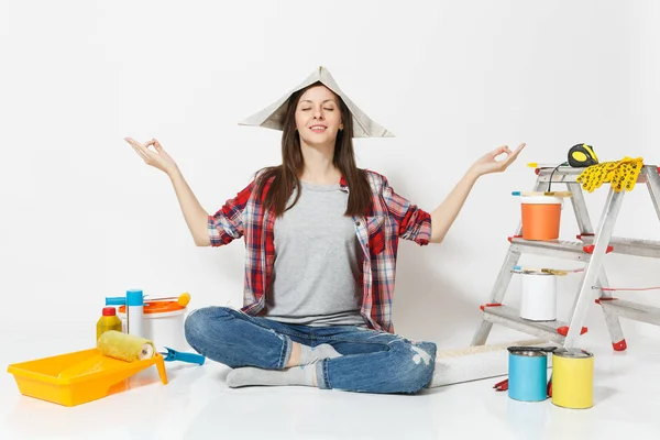 Ευτυχισμένη γυναίκα με καπέλο εφημερίδα που κάθονται στο πάτωμα, διαλογισμό, γιόγκα, χαλάρωση με όργανα για δωμάτιο διαμέρισμα ανακαίνιση που απομονώνονται σε λευκό φόντο. Ταπετσαρία κόλλημα εργαλεία. Επισκευή concept home. — Φωτογραφία Αρχείου