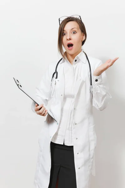 Impresionada joven doctora alterada con estetoscopio, gafas aisladas sobre fondo blanco. Doctora en bata médica con tarjeta de salud en la carpeta del bloc de notas. Personal sanitario, concepto de medicina . — Foto de Stock