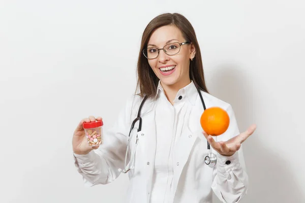 Sonriente joven doctora confiada con estetoscopio, gafas aisladas sobre fondo blanco. La doctora en bata médica sostiene la botella con pastillas, naranja. Personal sanitario, concepto de medicina . — Foto de Stock