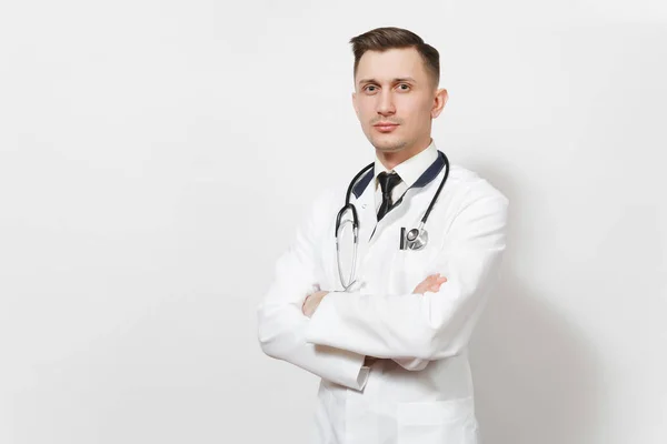 Serious confidente experimentado guapo joven médico aislado sobre fondo blanco. Médico en uniforme médico, estetoscopio cogido de la mano. Personal sanitario, salud, concepto de medicina . — Foto de Stock