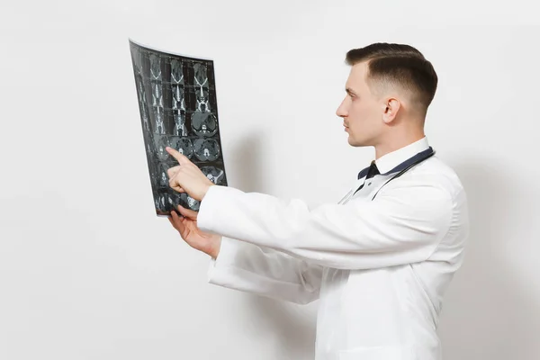 Enfocado joven médico guapo sostiene rayos X imagen radiográfica ct scan mri aislado sobre fondo blanco. Médico en uniforme médico, estetoscopio. Personal sanitario, salud, concepto de medicina . — Foto de Stock