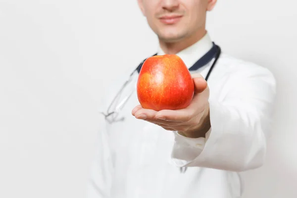 Primer plano retrato médico hombre aislado sobre fondo blanco. Médico en uniforme médico, estetoscopio con manzana roja. Personal sanitario, concepto de salud. Nutrición adecuada. Copiar espacio . — Foto de Stock