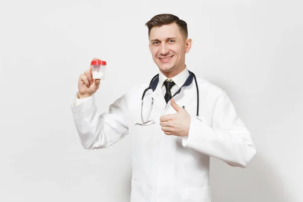 Sorridente esperto bel giovane medico isolato su sfondo bianco. Medico maschio in uniforme medica, stetoscopio contenente flacone con pillole bianche. Personale sanitario, salute, concetto di medicina . — Foto Stock