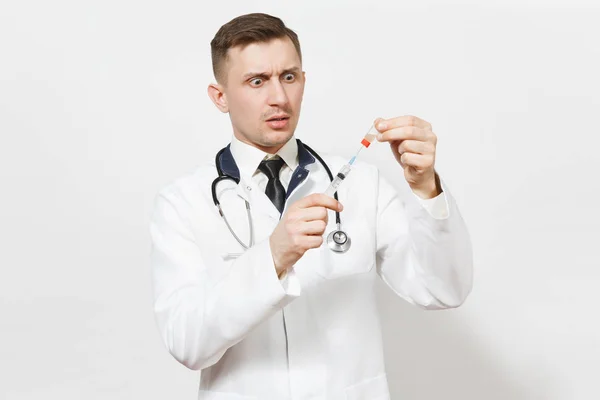 Серйозний молодий лікар ізольований на білому тлі. Чоловік-лікар в медичній формі, стетоскоп малює рідку медицину з пляшки шприцом з голкою. Медичний персонал, концепція медицини . — стокове фото