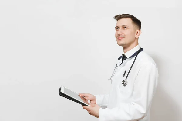 Confiante experimentou bonito jovem médico homem isolado em fundo branco. Médico masculino em uniforme médico, estetoscópio segurando computador tablet pc. Pessoal de saúde, saúde, conceito de medicina . — Fotografia de Stock