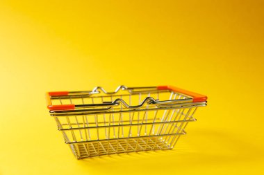 Metal Market sepeti indirdi kolları ve Sarı zemin üzerine izole turuncu plastik elemanları süpermarkette alışveriş için kapatın. Alışveriş kavramı. Kopya alanı reklam için