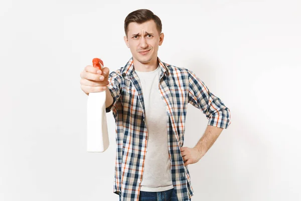 Jonge huishoudster man in geruit overhemd wit lege lege schoonmaak spray fles houden met schonere vloeistof geïsoleerd op een witte achtergrond. Man huis klusjes doen. Ruimte voor reclame kopiëren. — Stockfoto