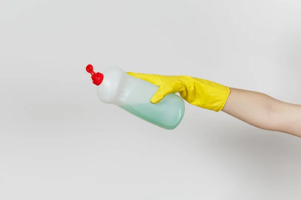 Close up van vrouwelijke hand in gele handschoenen wachtruimten uitstorten witte fles met groene schonere vloeistof for afwassen met plaats voor tekst geïsoleerd op een witte achtergrond. Schoonmaak leveringen concept — Stockfoto