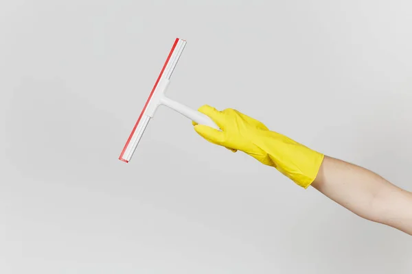 Nahaufnahme der weiblichen Hand in gelben Handschuhen horizontal hält weißen Rakel für die Oberflächenreinigung mit roten Elementen auf weißem Hintergrund isoliert. Reinigungsmittelkonzept. Kopierfläche für Werbung — Stockfoto