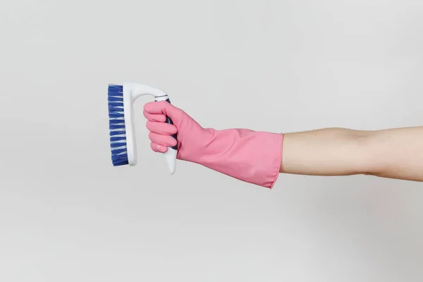 Primo piano di mano femminile in guanti rosa orizzontale tiene pennello bianco con fibre dure per la pulizia con elementi blu isolati su sfondo bianco. Concetto di forniture di pulizia. Copia spazio per l'annuncio — Foto Stock