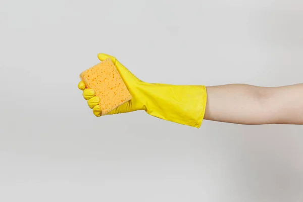 노란 장갑 가로 청소 및 설거지 흰색 배경에 고립 된 노란색-오렌지 스폰지를 보유 하 고 있는 여성 손의 닫습니다. 청소 공급 개념입니다. 광고에 대 한 공간을 복사 — 스톡 사진