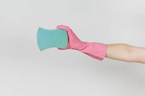 El primer plano de la mano femenina en guantes rosados horizontales sostiene una gran esponja azul para limpiar y lavar los platos aislados sobre fondo blanco. Concepto de artículos de limpieza. Copiar espacio para publicidad — Foto de Stock