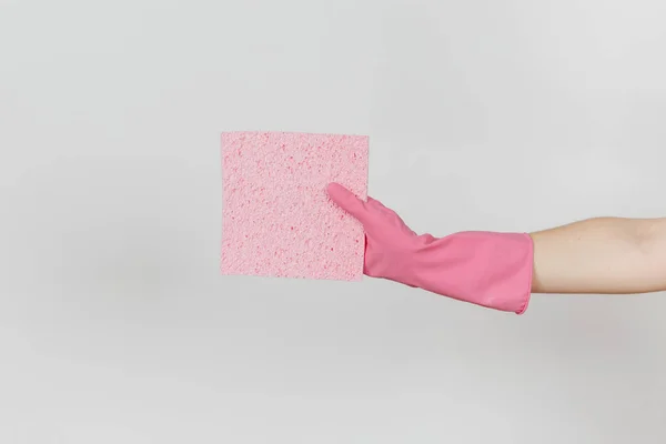 El primer plano de la mano femenina en guantes rosas horizontales sostiene la servilleta absorbente rosa para limpiar y lavar los platos aislados sobre fondo blanco. Concepto de artículos de limpieza. Copiar espacio para publicidad — Foto de Stock