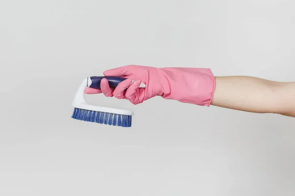 Primo piano di mano femminile in guanti rosa orizzontale tiene pennello bianco con fibre dure per la pulizia con elementi blu isolati su sfondo bianco. Concetto di forniture di pulizia. Copia spazio per l'annuncio — Foto Stock