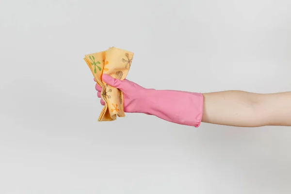 El primer plano de la mano femenina en guantes rosados sostiene y aprieta el trapo naranja estampado para limpiar y lavar los platos aislados sobre fondo blanco. Concepto de artículos de limpieza. Copiar espacio para publicidad — Foto de Stock