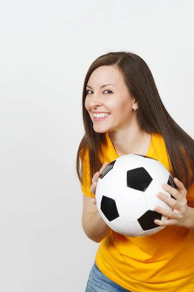 Hermosa joven europea alegre mujer feliz, fanático del fútbol o jugador en uniforme amarillo sosteniendo pelota de fútbol aislado sobre fondo blanco. Deporte, fútbol, salud, concepto de estilo de vida saludable . — Foto de Stock