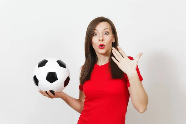 Beautiful European young cheerful happy woman, football fan or player in red uniform holding classic soccer ball isolated on white background. Sport, play football, health, healthy lifestyle concept.