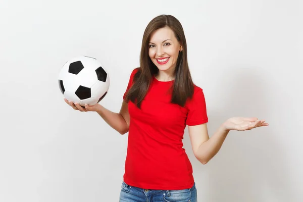 Hermosa joven europea alegre mujer feliz, fanático del fútbol o jugador en uniforme rojo sosteniendo pelota de fútbol clásico aislado sobre fondo blanco. Deporte, fútbol, salud, concepto de estilo de vida saludable . — Foto de Stock