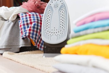 Buharlı Ütü, Çamaşırhane, yıkanmış renkli elbise Ütü kadar yakın aile giyim üzerine Ütü Masası beyaz arka plan üzerinde izole. Temizlik kavramı. Reklam için yer kopyalayın. Metin için yer.