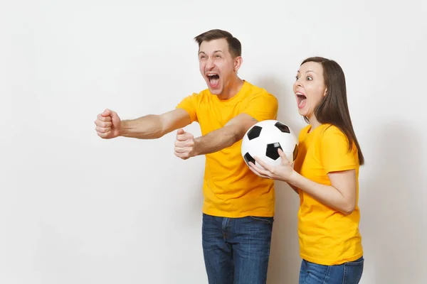 Amusant fou joyeux émotionnel jeune couple, femme, homme, fans de football en uniforme jaune remonter le moral équipe de soutien avec ballon de football isolé sur fond blanc. Sport, loisirs en famille, concept lifestyle . — Photo