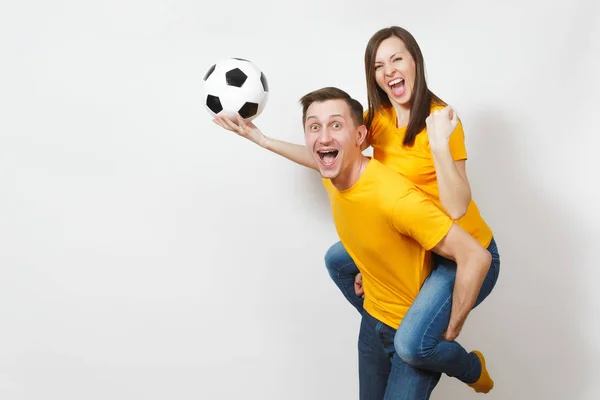 Inspirovaný mladý pár, Žena sedět na zádech, fanoušci člověka s fotbal míč jásající oblíbený fotbalový tým expresivní rozkládali rukama izolovaných na bílém pozadí. Rodinné rekreační, stylu života. — Stock fotografie